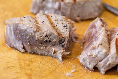 Chargrilled, pişmiş ve Ahşap Doğrama tahtası üzerinde dilimlenmiş tecrübeli orkinos biftek
