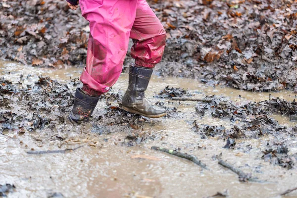 Young child playing in a mud puddle