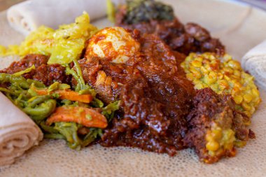 Injera tavuk ve yumurta Doro Wat, Chahrazad, sebze ve mercimek ile servis. Injera, Etiyopya, yerel yemeğiniyiyormuşsun teff unundan yapılmış bir hamur mayası gözleme olduğunu.