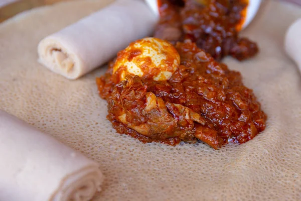 Injera tavuk ve yumurta Doro Wat ile servis. Injera teff unundan yapılmış bir hamur mayası gözleme olduğunu. Etiyopya, Eritre, Somali ve Cibuti Ulusal yemektir