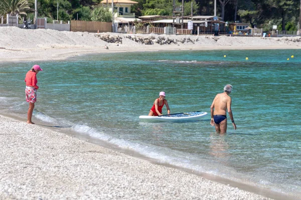 LEFKADA, GREECE - MAY 29 2018: Seniors enjoying beach based leisure activities in the sea off Agios Ioannis beach, Lefkada, Greece. — Stock Photo, Image