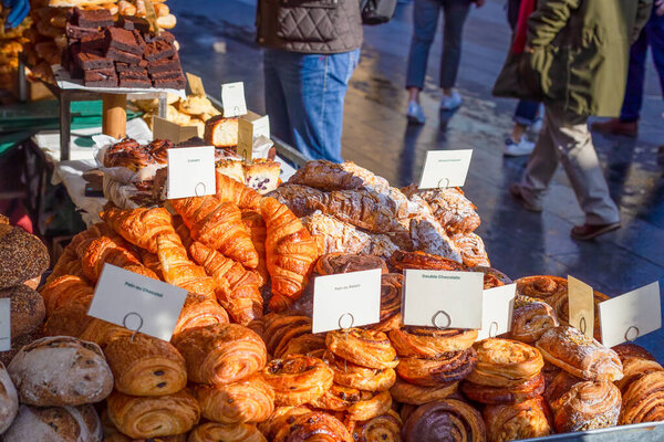 Variety of artisan pastries and breads for sale at a street market stall in the UK