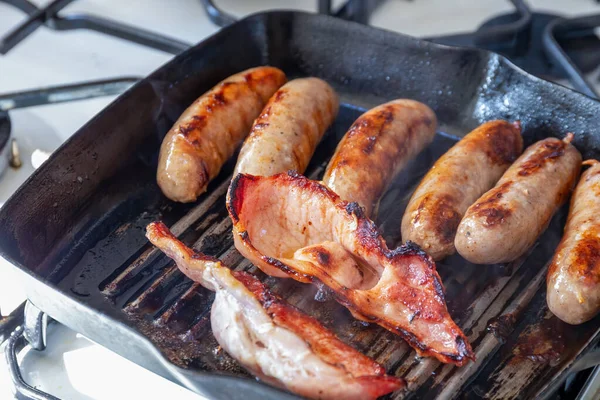Cumberland korv och bacon matlagning i en grillpanna — Stockfoto