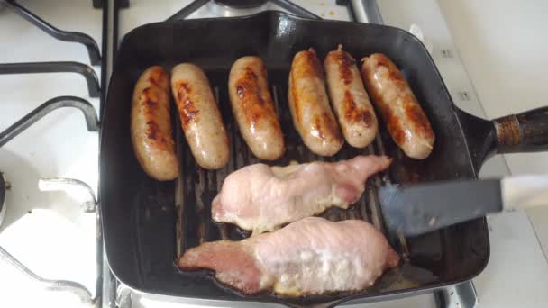 Cumberland sausages and bacon cooking in a griddle pan — Stock Video