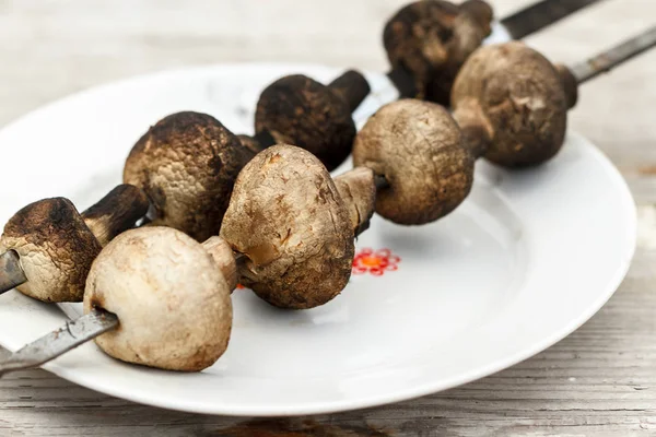 Grilled mushrooms on a white ceramic plate — Stock Photo, Image