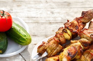 şiş kebap şişleri üzerinde. Taze sebze ile ahşap bir masaya. yeşil çim zemin üzerine Kebap