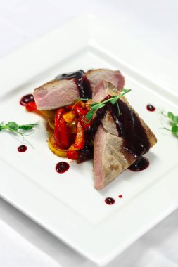 Restoran menü için beyaz tabakta sebze ızgara ve kiraz soslu biftek