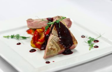 Restoran menü için beyaz tabakta sebze ızgara ve kiraz soslu biftek