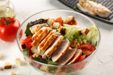 salata cesar tavuk ızgara Beyaz ahşap masa üzerinde cam kapta. Dekor taze sebze