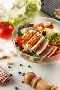 salata cesar tavuk ızgara Beyaz ahşap masa üzerinde cam kapta. Dekor taze sebze