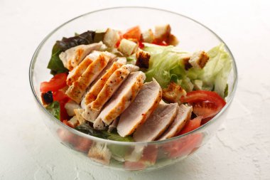 salata cesar tavuk ızgara beyaz masada cam kapta