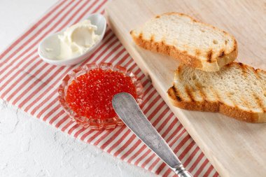 tereyağı ve ahşap kesme tahtası üzerinde kırmızı havyar ile tost