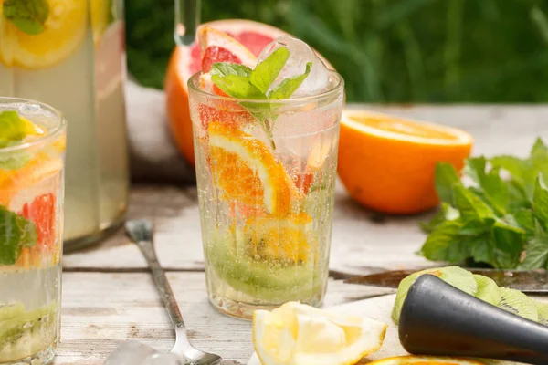 Narenciye limonata nane ile cam. Turuncu. Limon ve greyfurt. Yeşil zemin üzerine.