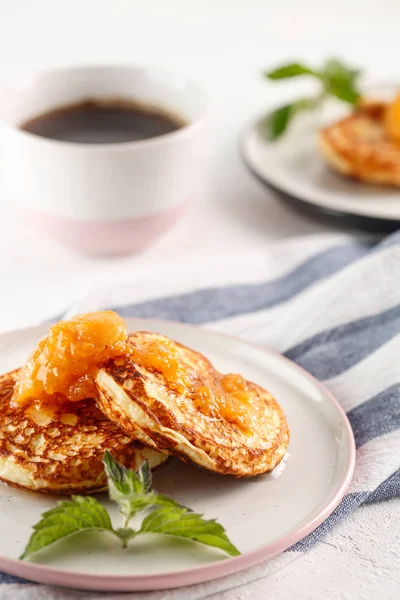 Quark-Pfannkuchen, Syrniki, Quark-Krapfen. Frühstück mit Kaffee, Käsekuchen und Marillenmarmelade. — Stockfoto