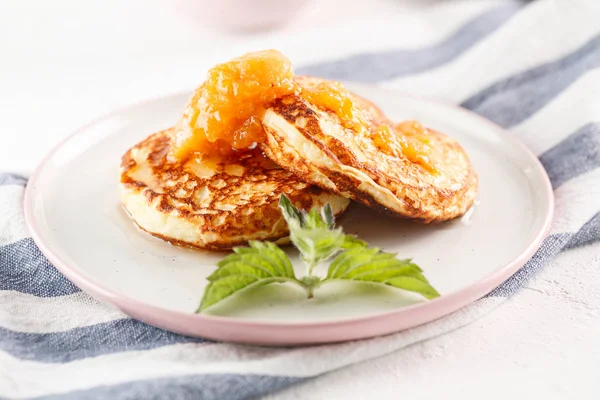 Quark-Pfannkuchen, Syrniki, Quark-Krapfen. Frühstück auf weißem Hintergrund Käsekuchen und Marillenmarmelade. — Stockfoto