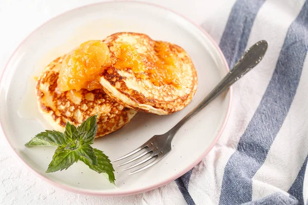 Quark-Pfannkuchen, Syrniki, Quark-Krapfen. Frühstück auf weißem Hintergrund Käsekuchen und Marillenmarmelade. Ansicht von oben. Kopierraum — Stockfoto