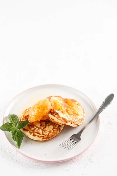 Quark-Pfannkuchen, Syrniki, Quark-Krapfen. Frühstück auf weißem Hintergrund Käsekuchen und Marillenmarmelade. Flatlay. Ansicht von oben. Kopierraum — Stockfoto