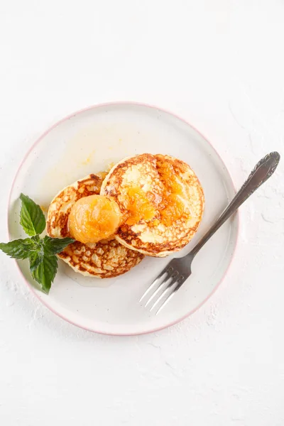 Cottage cheese pancakes, syrniki, curd fritters. Breakfast on white background cheesecake and apricot jam. Flatlay. Top view. copyspace — Stock Photo, Image