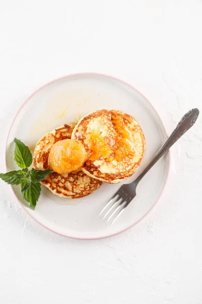 Quark-Pfannkuchen, Syrniki, Quark-Krapfen. Frühstück auf weißem Hintergrund Käsekuchen und Marillenmarmelade. Flatlay. Ansicht von oben. Kopierraum — Stockfoto