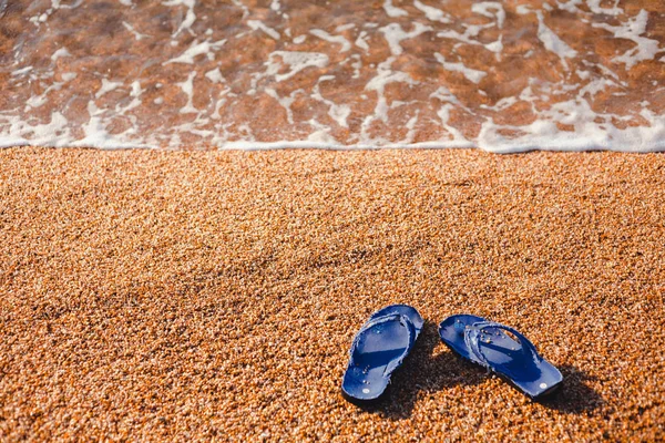 蓝色拖鞋在海滩上略过3月在海的背景 — 图库照片