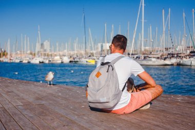 adam gezgin yat liman Barcelona yakın oturan bir sırt çantası ile