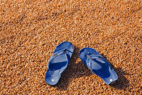 蓝色拖鞋在海滩上略过3月在海的背景 — 图库照片