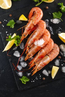 kerevitleri baharatlar, limon ve otlar siyah bir arka plan ile. Baharatlar ve limon ile kaplan karides. Üstten görünüm