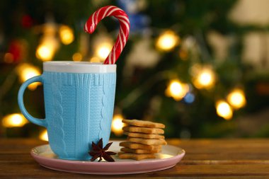 mavi kupa ile Noel candy ve gingerbread çerezleri Noel ışıkları arka plan üzerinde