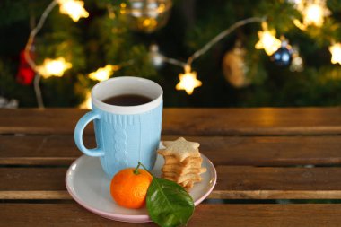 Çay Kupa, mandalina ve zencefil çerezleri Noel ışıkları zemin üzerine mavi
