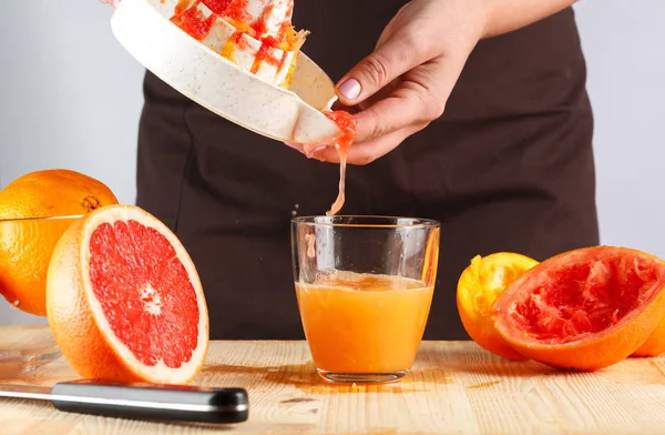 Girl preparing fresh citrus juice. gray background — Stock Photo, Image