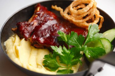 dökme demir tavada patates püresi ile pişmiş barbekü kaburga