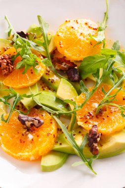 bej plaka üzerinde taze avokado ve turuncu salata