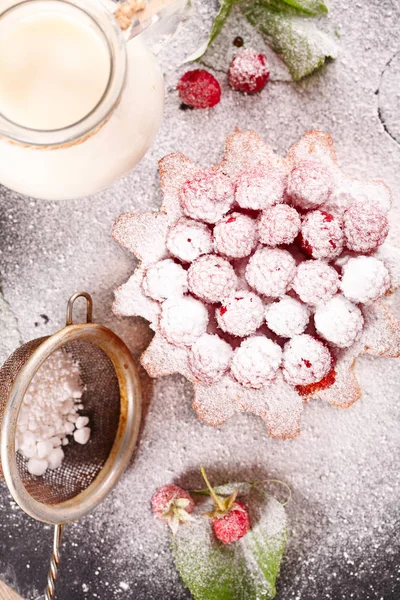 Muffin versierd met frambozen en groene bladeren — Stockfoto