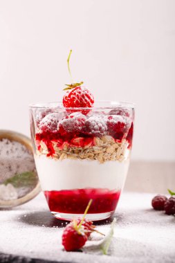 Cam bardakta yulaf ezmeli taze ahududu ve çilekli lezzetli bir tatlı. Verin.