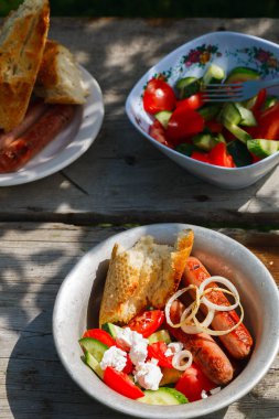 Mangal. Köy yemeği. Kızarmış sosis, sebze salatası, soğan ve ızgara ekmek..