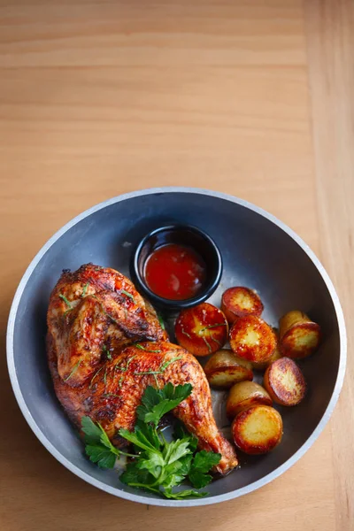 Жареная курица с детским картофелем и томатным соусом — стоковое фото