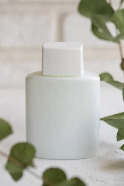 Beyaz tekstil arka planında beyaz plastik kozmetik şişe