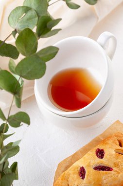 Beyaz arka planda eski bir tabakta ahudududulu poğaça. Çayla kahvaltı. Scandi tarzı