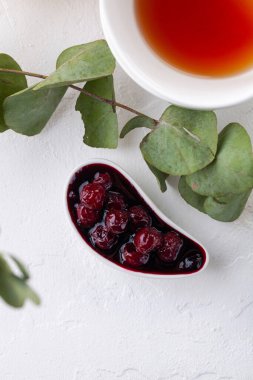 Beyaz soslu vişne reçeli ve arka planda bir kupa çay. Scandi tarzı