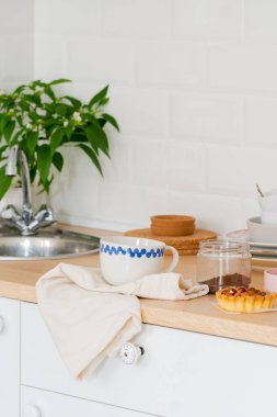 Beyaz mutfak içi. İskandinav iç tasarımı açık renkli bitkiler ve aksesuarlarla. Mutfak detayları. Güneşli bir gün