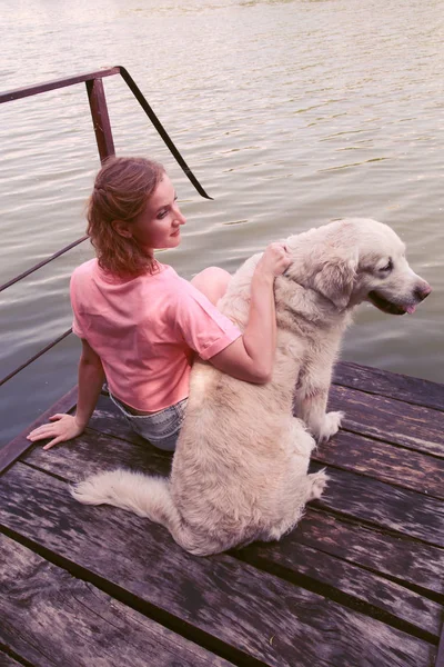 Young attractive girl with her pet dog at a beach. Girl hugging — Stock Photo, Image