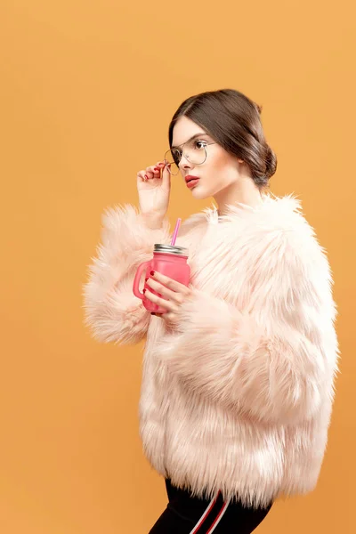 Kvinna med rosa dricka burk på gula — Stockfoto