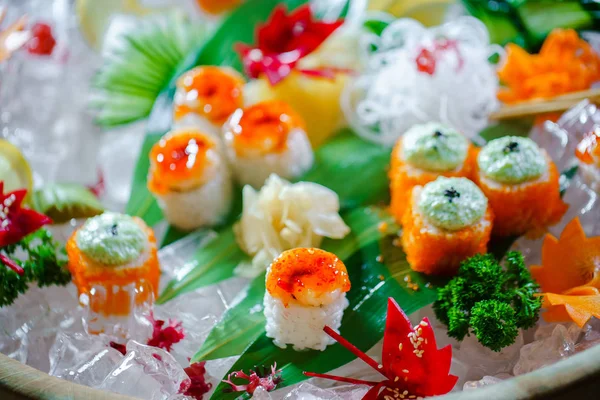 Много суши-роллов с разными начинками. Выстрел приготовленной классической японской кухни подается на льду. Фоновое изображение — стоковое фото