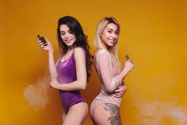 Kvinnor i bodysuits vaping i studio — Stockfoto