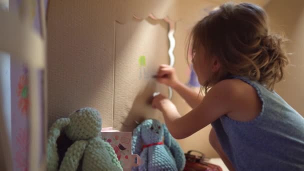 Очаровательная девушка играет в игрушечном домике — стоковое видео