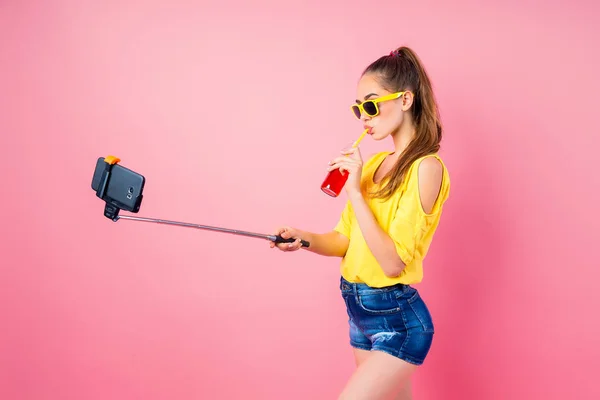 Lachende tienermeisje met drank maken selfie met stok — Stockfoto