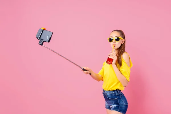 Lachende tienermeisje met drank maken selfie met stok — Stockfoto