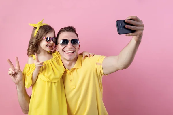 Ritratto di famiglia felice di due persone. Papà e figlioletta fanno selfie con lo smartphone. Fotografia orizzontale a colori . — Foto Stock