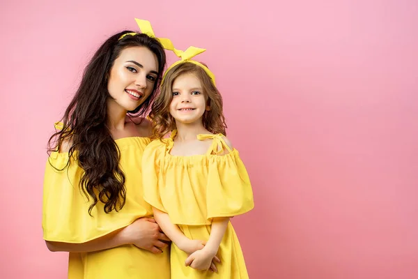 Wanita muda dengan anak manis berpose dalam gaun kuning — Stok Foto