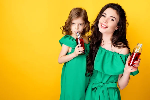 Aantrekkelijke brunette met dochter houden van rode dranken — Stockfoto